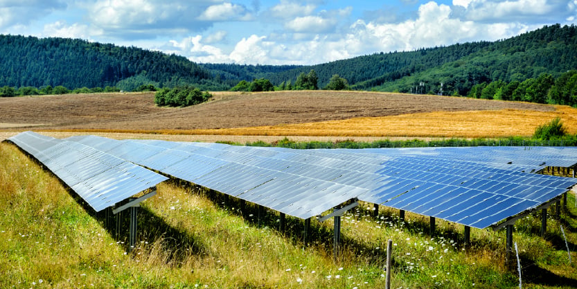 solar farm in a field surrounded by hills